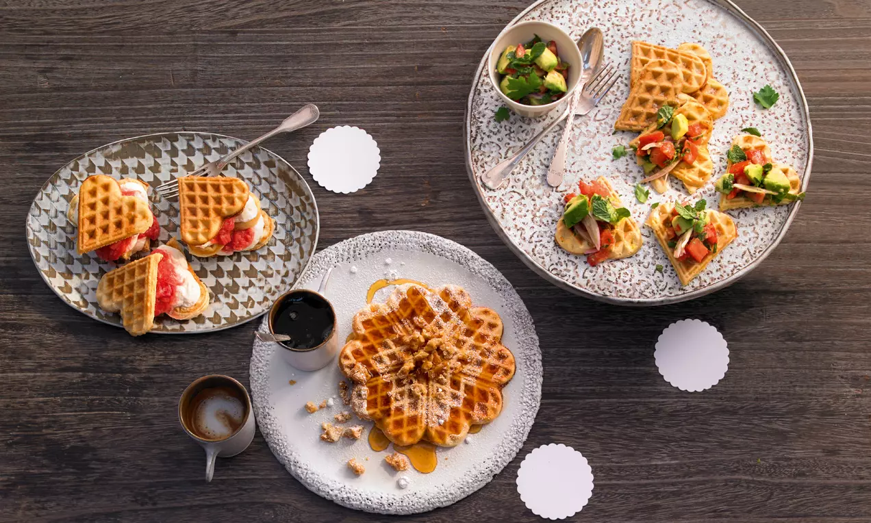 Herzförmige und runde Waffeln goldbraun, dünne Textur mit knusprigen Kanten, serviert süß und herzhaft auf dekorativen Tellern